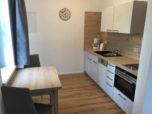a kitchen with white cabinets and a wooden table at "Villa Seute Deern" Trassenheide, Familie Meutzner in Trassenheide