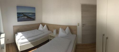 a small room with two beds and a mirror at "Villa Seute Deern" Trassenheide, Familie Meutzner in Trassenheide