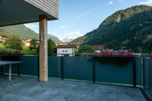 a balcony with a blue fence and flowers at Appartements Ausblick in Sankt Gallenkirch