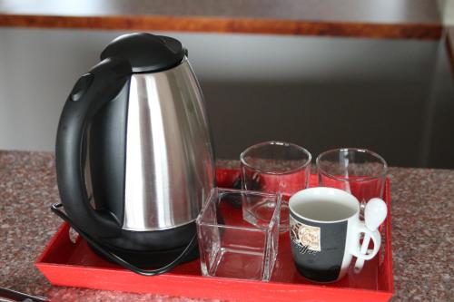 a tea kettle and two glasses on a red tray at Casa Bucovineana in Suceava