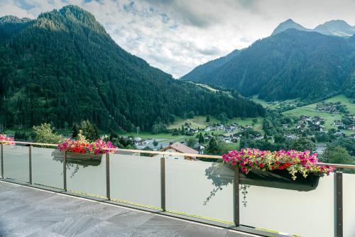 a balcony with flowers on it with a view of a valley at Appartements Ausblick in Sankt Gallenkirch