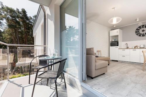 a room with a balcony with a table and chairs at Villa Ula Apartament in Pobierowo