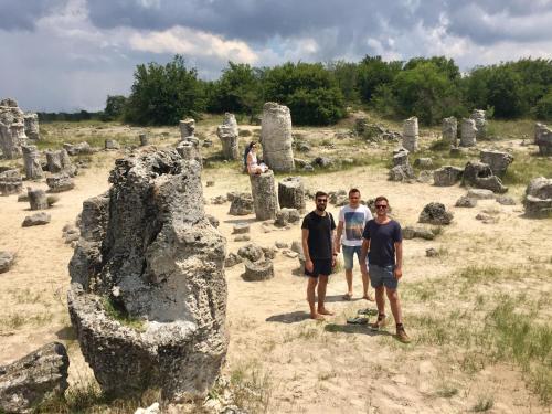 a group of people standing in a field with rocks at Nomado Hostel in Varna City