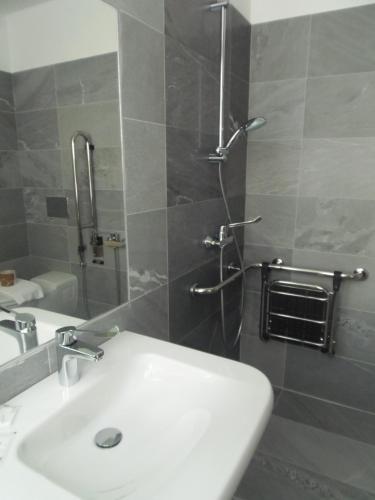 a bathroom with a white sink and a shower at Albergo Dongo in Dongo