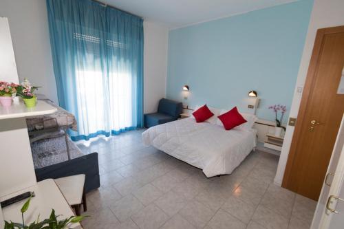 um quarto com uma cama com almofadas vermelhas em Hotel Giannella em Rimini
