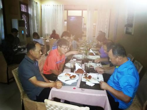a group of people sitting at a table eating food at Transit Airport B&B in Dar es Salaam