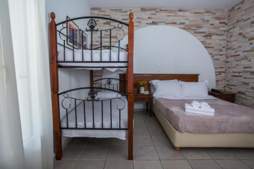 a bedroom with a bunk bed with a ladder at Naxos Palace Hotel in Stelida