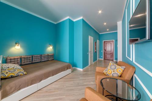 ゲレンジークにあるКвартиры-студии в Геленджикеの青い壁のベッドルーム1室、ベッド1台、ソファが備わります。