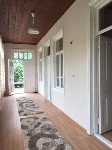 an empty hallway with white walls and a wooden ceiling at Lazuri Keria Family Guesthouse in Khoni