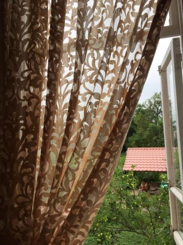 a curtain on a window in a room at Lazuri Keria Family Guesthouse in Khoni