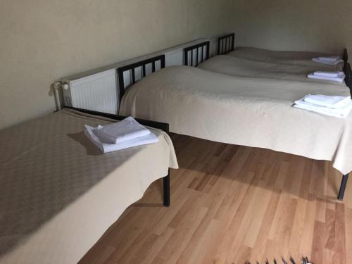 two beds in a room with wooden floors at Lazuri Keria Family Guesthouse in Khoni