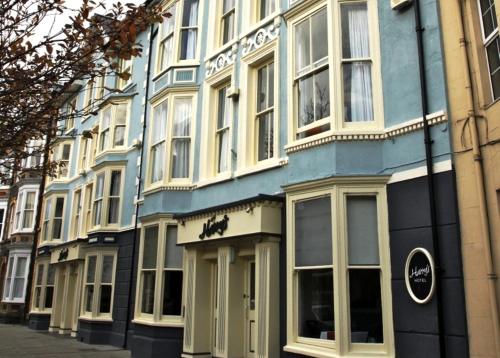 a blue building with white windows on a street at Harry's Hotel & Restaurant in Aberystwyth