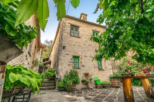 an old stone building with flowers in front of it at Morfeas Guesthouse in Papigko