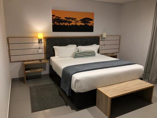 Travelodge في غابورون: غرفة نوم بسرير كبير في غرفة