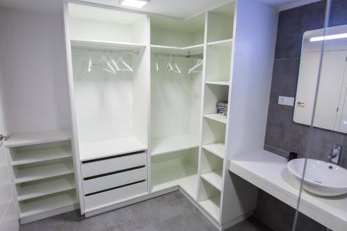 a white walk in closet with a sink and a mirror at bungalow con gran terraza con vistas in Maspalomas