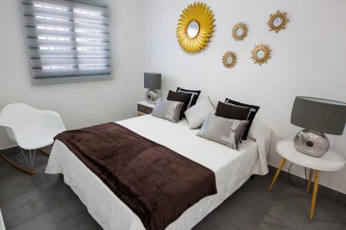 a bedroom with a bed and a mirror on the wall at bungalow con gran terraza con vistas in Maspalomas