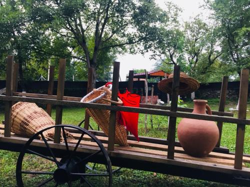 a group of vases sitting on a wooden bench at Lazuri Keria Family Guesthouse in Khoni