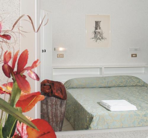 una piccola camera con letto e pianta di Hotel Liverpool a Cervia