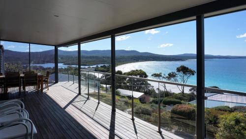 a view of the ocean from the balcony of a house at SEA EAGLE COTTAGE Amazing views of Bay of Fires in Binalong Bay
