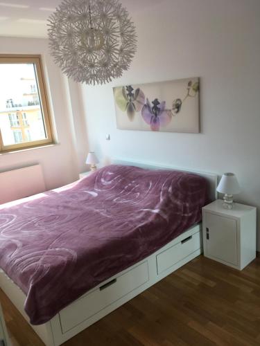 a bedroom with a bed with a purple blanket at Korkyra in Zagreb