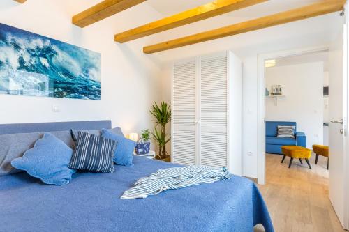 um quarto com uma cama azul e um cobertor azul em Lux Apartment Medulin Istria em Medulin