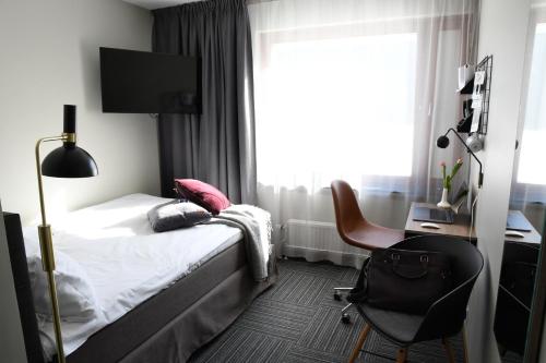 a bedroom with a bed and a desk and a chair at Best Western Malmia Hotel in Skellefteå