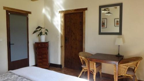 a bedroom with a desk and a bed and a table at Le Moulin du Cluzeau in Chaillac
