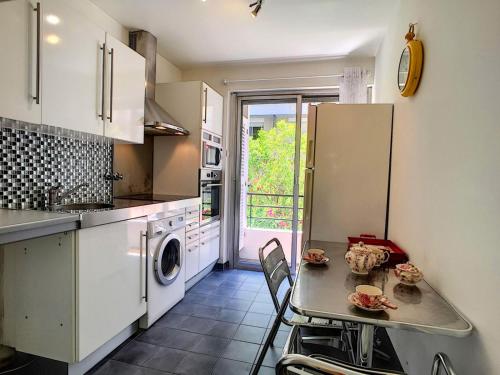 La cuisine est équipée d'une table, d'un évier et d'un réfrigérateur. dans l'établissement Nestor&Jeeves - DEBUSSY TERRASSE - Central - By shopping area, à Nice