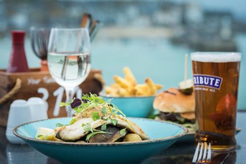 a table with a bowl of food and a glass of beer at Pedn-Olva in St Ives
