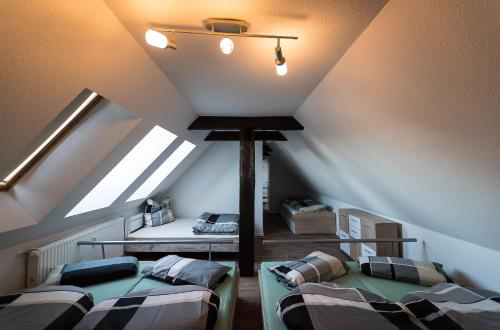 a attic room with two beds and a ceiling at Buri Island in Hoyerswerda