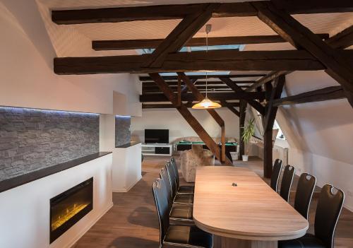 a dining room with a fireplace and a wooden table and chairs at Buri Island in Hoyerswerda