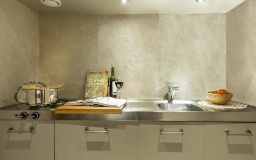a kitchen with a sink and a counter top at Aparthotel Mariano Cubi Barcelona in Barcelona