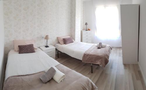 sypialnia z 2 łóżkami i oknem w obiekcie Apartamento "El Abuelo" w mieście Calahorra