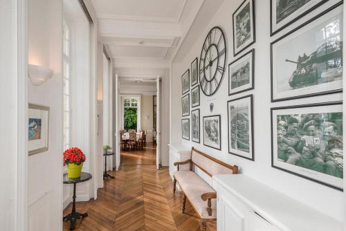 a hallway with black and white pictures on the walls at Château Baffy in Colombiers-sur-Seulles