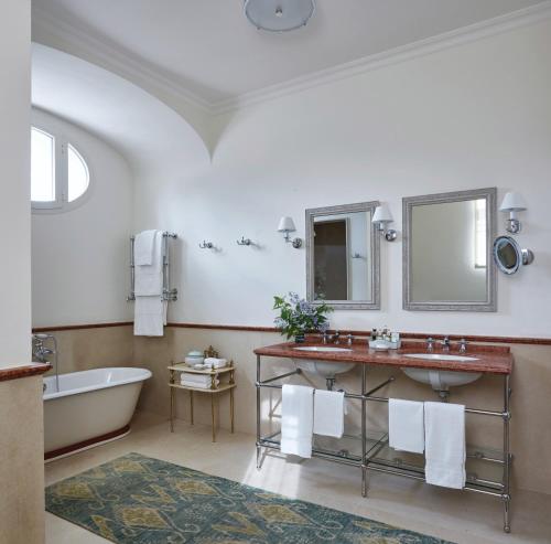 bagno con vasca, lavandino e specchio di Villa Margherita by Belmond a Ravello