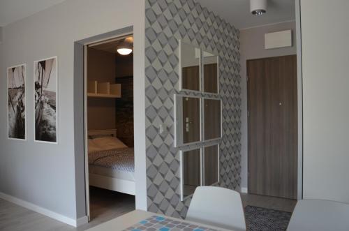 ポゴジェリツァにあるApartament 45 Baltic Park Pogorzelicaの鏡付きの部屋、ベッド付きのベッドルーム1室が備わります。