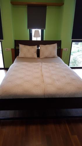 a large bed in a room with green walls at Wollefstuerm in Echternach