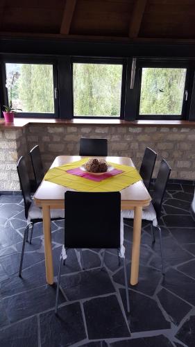 a table with chairs in a room with windows at Wollefstuerm in Echternach
