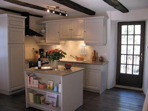 a kitchen with white cabinets and a counter top at L'Ancienne Ecole in Entraygues-sur-Truyère