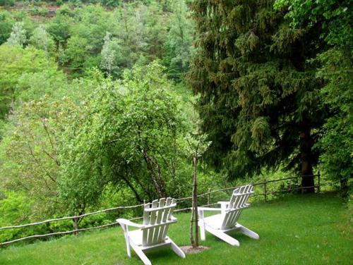 two white chairs sitting on top of a field at L'Ancienne Ecole in Entraygues-sur-Truyère