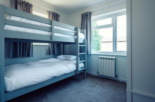a bedroom with two bunk beds and a window at The Imperial Hotel in St Saviour Guernsey