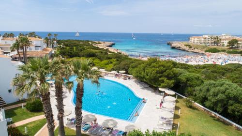 a resort with a swimming pool and a beach at Grupotel Aldea Cala'n Bosch in Cala'n Bosch
