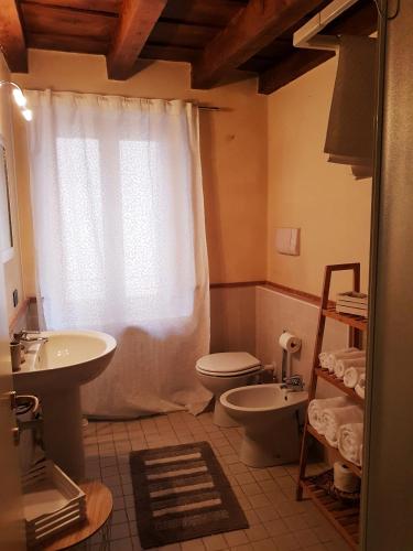 a bathroom with a sink and a toilet and a window at Elly's House in Verona