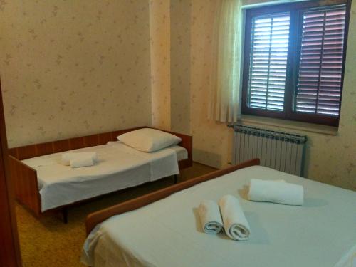 sypialnia z 2 łóżkami i ręcznikami w obiekcie Apartmani Tonica w Sukošanie