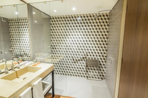 ein Bad mit einer Dusche und einem Waschbecken in der Unterkunft GHL Hotel Bogota Occidente in Bogotá