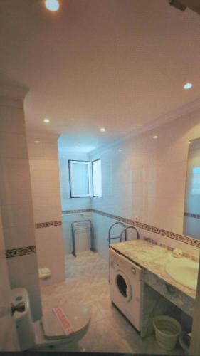 a bathroom with a sink and a washing machine at Apartamento Neptuno in Nerja