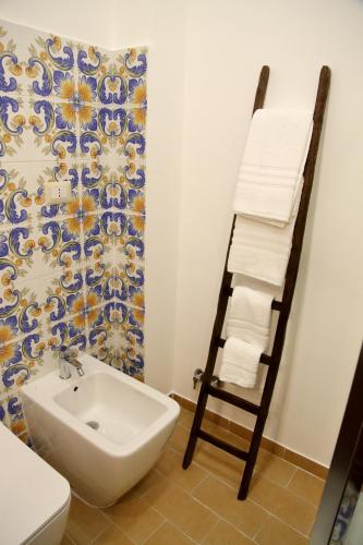 a bathroom with a towel ladder next to a sink at Domus Cuseni in Taormina
