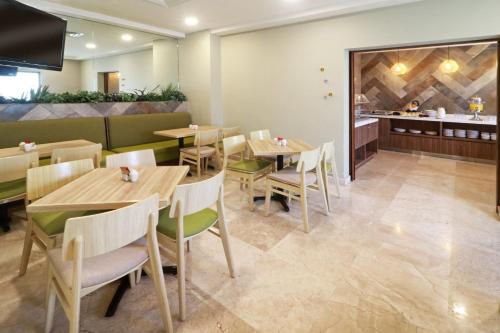 a restaurant with wooden tables and chairs and a counter at Wyndham Garden Monterrey Valle Real in Monterrey