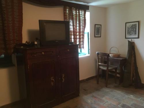 a living room with a television on a dresser at Lovačka kuća in Veliko Središte