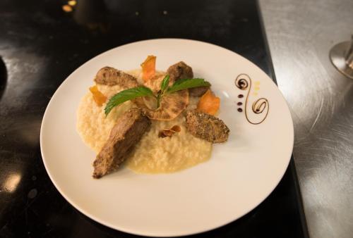 a plate of food with meat and vegetables on a table at Hotel Rovanada Wellness & BergNatur in Vals